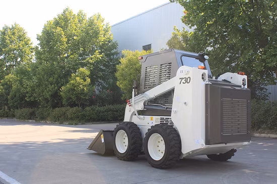 Chargeuse compacte Vochains avec balayeuse utilisée pour l'entretien des routes
